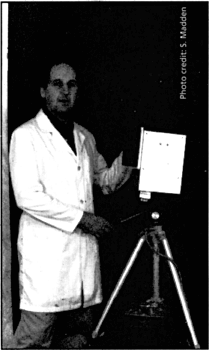 man posing with an aura camera